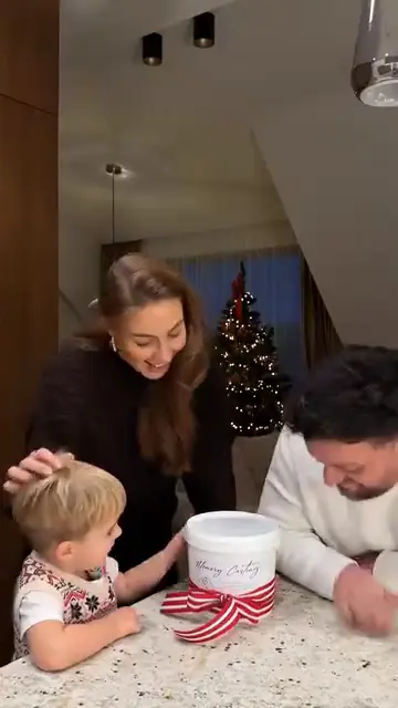 Šeima su vaiku prie virtuvės stalviršio šventiškuose namuose.